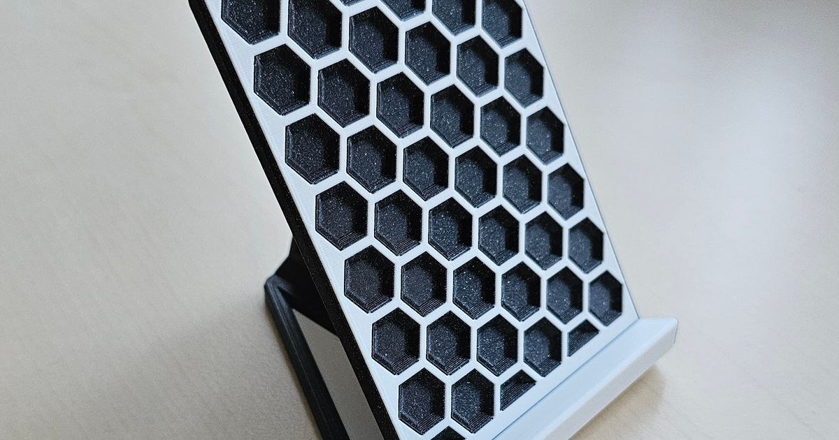 3D printed stand with hexagon pattern holding phone on desk
