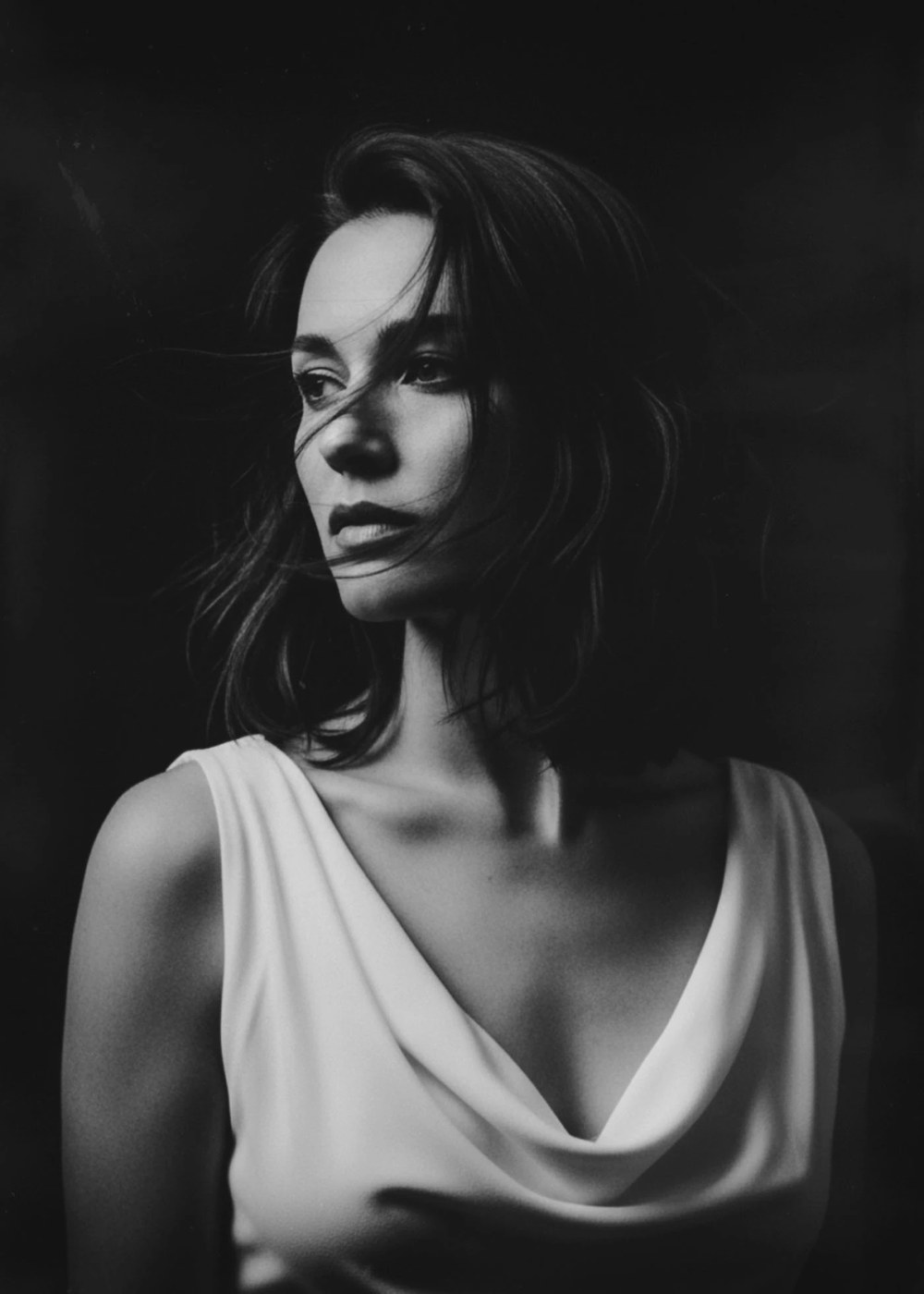 black and white portrait photography analog — tight framing, dark background, analog grain structure